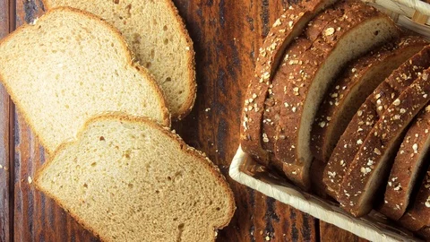 Wholegrain sliced organic bread composed of oats and flax seeds on wooden tab Stock Footage 104580659