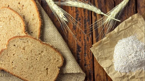 Wholegrain sliced organic bread composed of oats and flax seeds on wooden tab Stock Footage 104580889