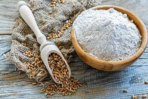 Wholegrain wheat flour in a wooden bowl. Stock Photos