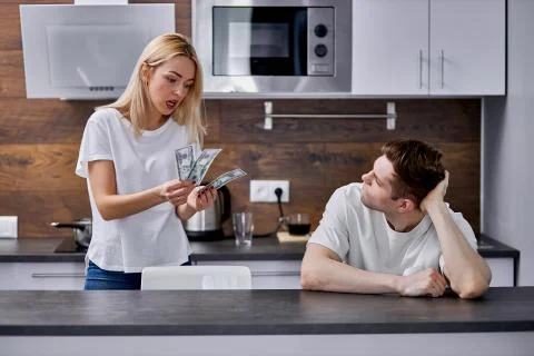 Why do you earn so little money unhappy woman talk to lazy husband Photos