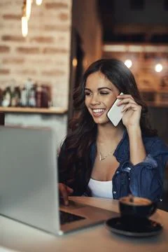 Why dont we discuss this over coffee. a young woman answering her cellphone Stock Photos