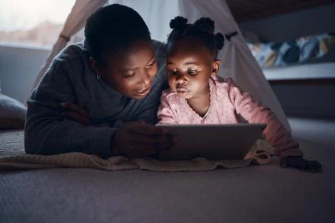 Why dont you choose a story. a mother reading bedtime stories with her daughter Stock Photos