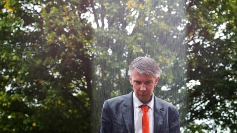 Why is it raining on me - sad businessman caught out in the rain Stock-Footage 80993968