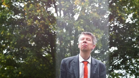Why is it raining on me - sad businessman caught out in the rain Stock-Footage 80995807