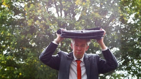 Why is it raining on me - sad businessman caught out in the rain Video stock 80996797