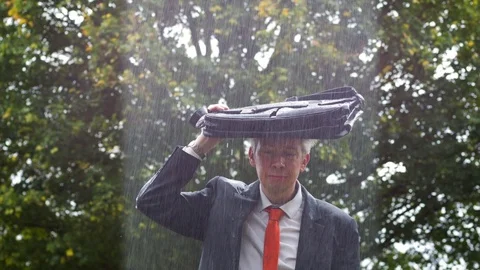 Why is it raining on me - sad businessman caught out in the rain Stock-Footage 80997155