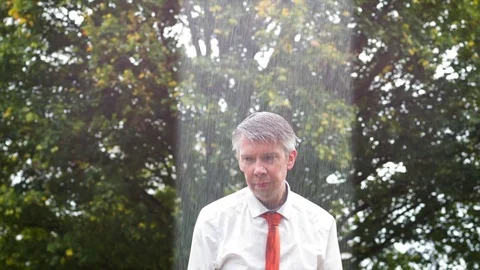 Why is it raining on me - sad businessman caught out in the rain Stock-Footage 80997835