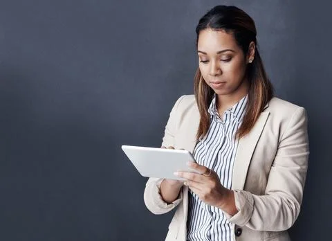 Why not simplify business. Studio shot of a young businesswoman using her tablet Stock Photos