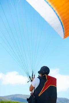 Why walk when you can fly. a man paragliding on a sunny day. Fotos Stock