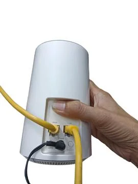 Wi-Fi access point connects devices via cables against a white background. Stock Photos