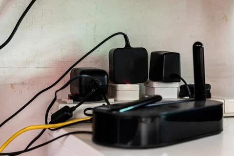 A Wi-Fi, socket and cables behind messy Stock Photos