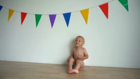 Two-year old boy with pants down wearing diapers, Stock Photo