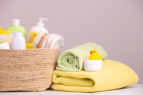 Wicker basket with baby cosmetic products, bath accessories and rubber duck o Stock Photos