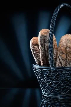 Wicker basket with bread on black bacground 库存照片