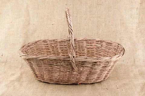 Wicker basket on burlap background Stock Photos