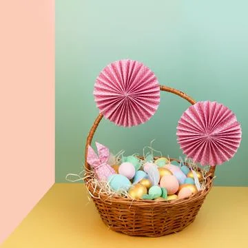 Wicker basket with colorful Easter eggs in pastel colors and decorated with Stock Photos