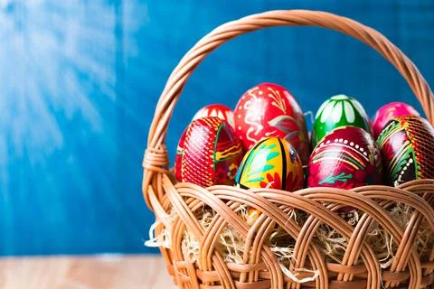 Wicker basket with colorful easter eggs. Stock Photos