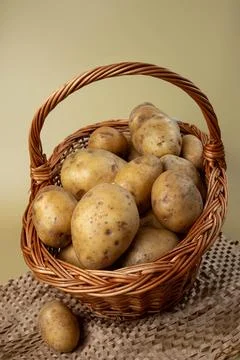 Wicker basket full of potatoes, placed on brown crepe paper, Stock Photos