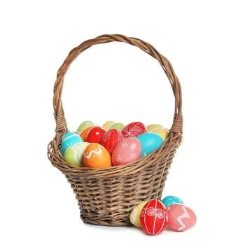 Wicker basket with painted Easter eggs on white background Stock Photos