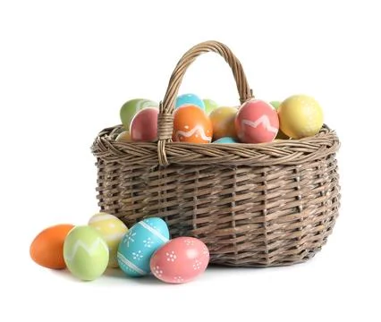 Wicker basket with painted Easter eggs on white background Stock Photos