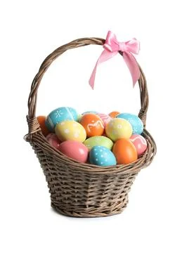 Wicker basket with painted Easter eggs on white background Stock Photos