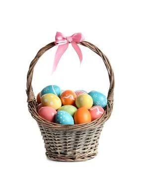 Wicker basket with painted Easter eggs on white background Stock Photos