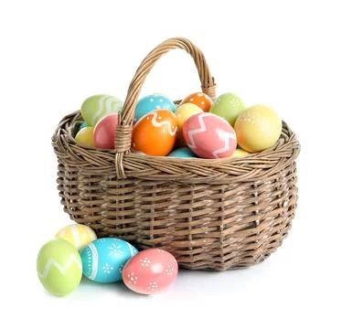 Wicker basket with painted Easter eggs on white background Stock Photos