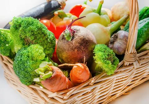 Wicker basket with a set of vegetables collected in the garden: broccoli, bee Stock Photos