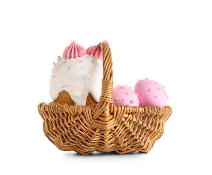 Wicker basket with sweet Easter cake and painted eggs on white background Stock Photos