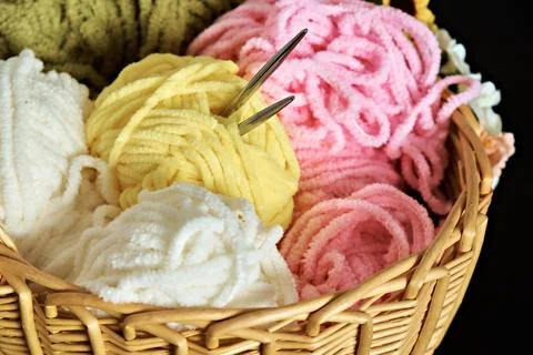 Wicker basket with various knitting threads and knitting needles. Up close Stock Photos