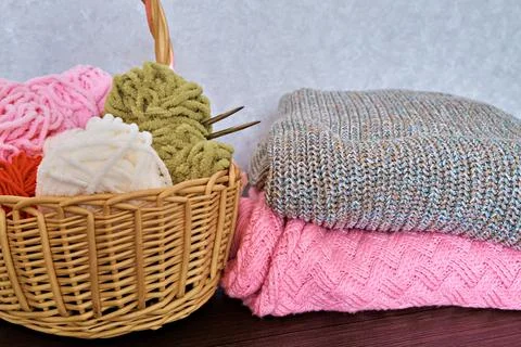 Wicker basket with various threads for knitting and knitted products from the Stock Photos