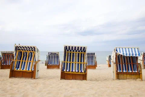 Wicker beach baskets with white-blue striped fabric rest on Kolobrzegs sand.. Stock Photos