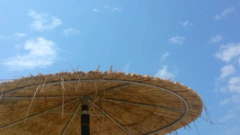 Wicker beach umbrellas under blue sky with clouds, Nea Iraklia, Halkidiki Greece Stock Footage 113283618