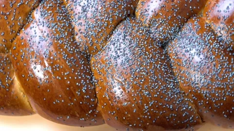 Wicker bread on a turntable. Challah with sesame seeds on wooden background Stock Footage 159446282