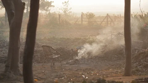 A wicker chair in front of a dwindling fire during a Nepal day Stock Footage 91055626