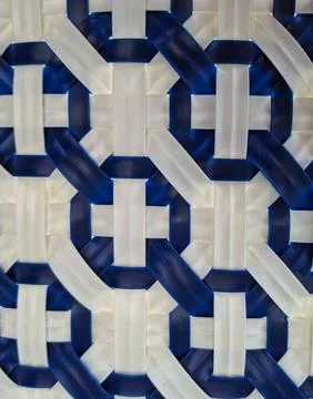 Wicker chair texture featuring intricate geometric pattern in blue and whit.. Stock Photos