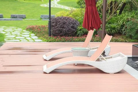 Wicker deck chair and table in the beautiful summer park with green lawns and Foto stock