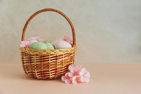 Wicker Easter Basket with Pastel Eggs and Flowers. Soft Spring Decor Stock Photos