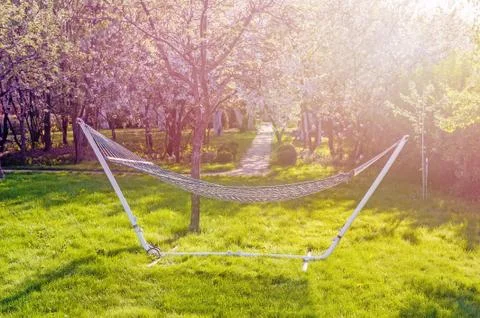 Wicker hammock for camping close - up on the background of blooming spring Stock Photos