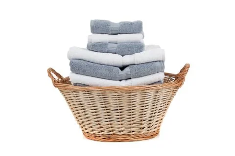 Wicker laundry basket full of white and gray towels Stock Photos