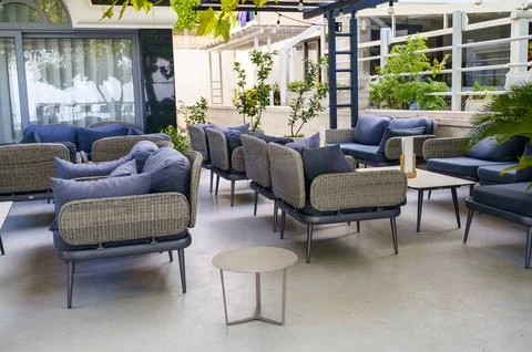 Wicker lounge seating set on a spacious open-air hotel patio under a shade 库存照片