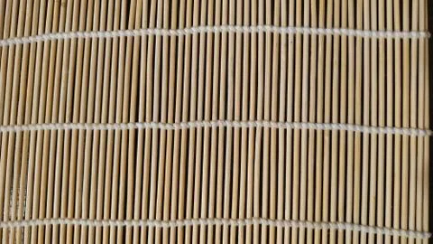 Wicker mat, decorative napkin of thin rods fastened with textile thread. Clos Stock Photos