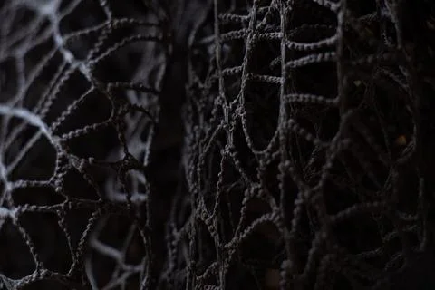 Wicker mesh of threads as a background with a soft blurred focus in the dar.. Stock Photos