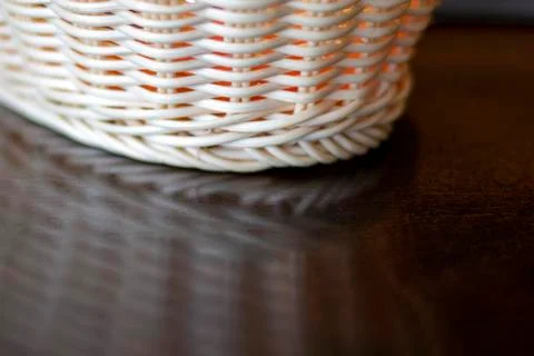 Wicker plate reflected on the table. Stock Photos