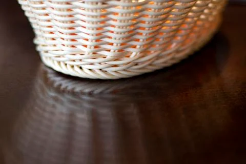 Wicker plate reflected on the table. Stock Photos