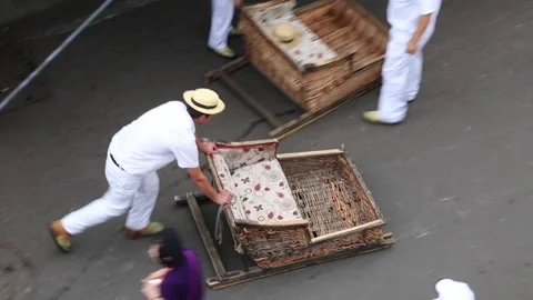 A Wickerman gets a toboggan ready for some tourist in Funchal Stock Footage 150187226