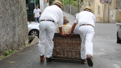 Wickermen pull toboggans down the streets of Funchal Stock Footage 150187228