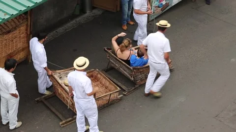Wickermen pull toboggans down the streets of Funchal Stock Footage 150187233