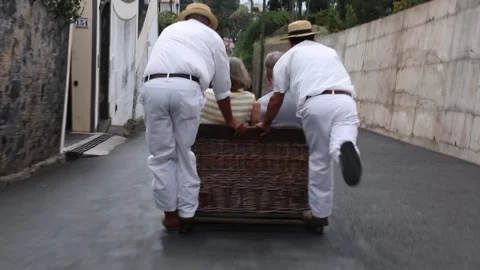 Wickermen push a toboggan down the streets of Funchal Stock Footage 150187224