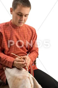 Wickerwork. Boy divides twig into two parts Stock Photos